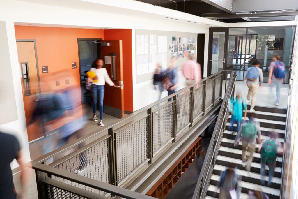 busy high school corridor during recess with blurred students and staff